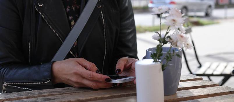 Young woman messaging while having coffee