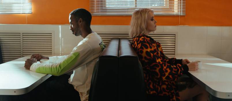 Man and woman sitting back to back after fight