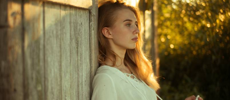 Woman leaning on wooden wall
