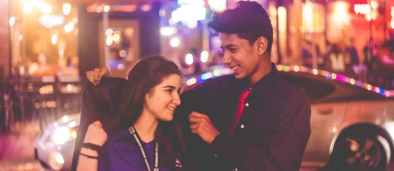 Man giving jacket to woman