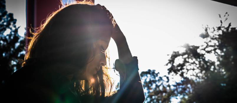 Woman holding head looking up