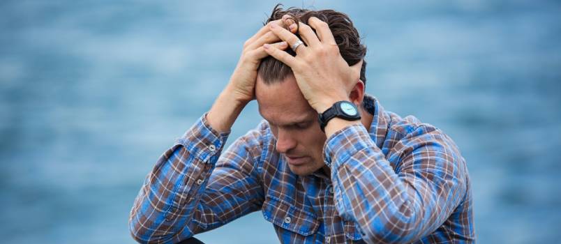 Depressed man sitting holding his head