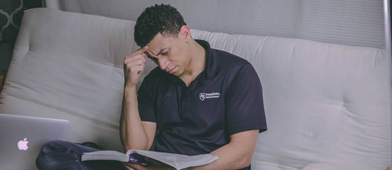 Man sitting on sofa reading book