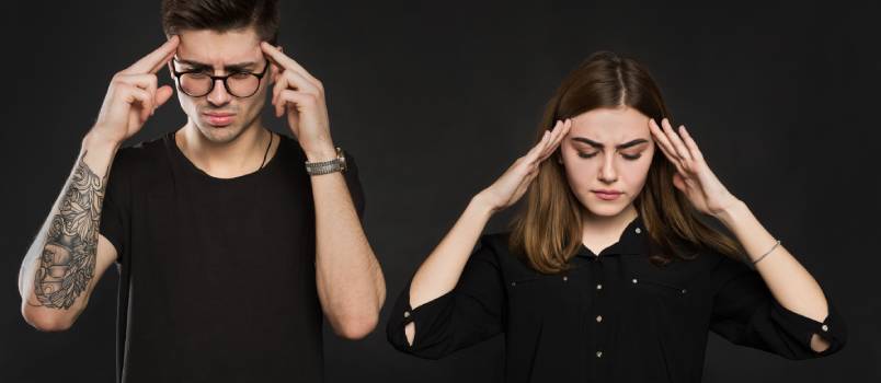 Stressed couple holding their heads