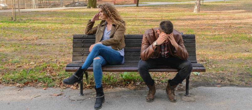 Depressed man and woman sitting on bench