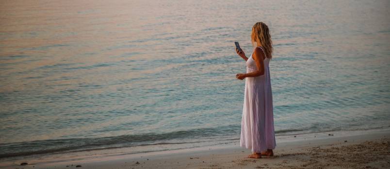 Woman using smartphone near beach