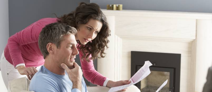 Couple using laptop and discussing financial bills