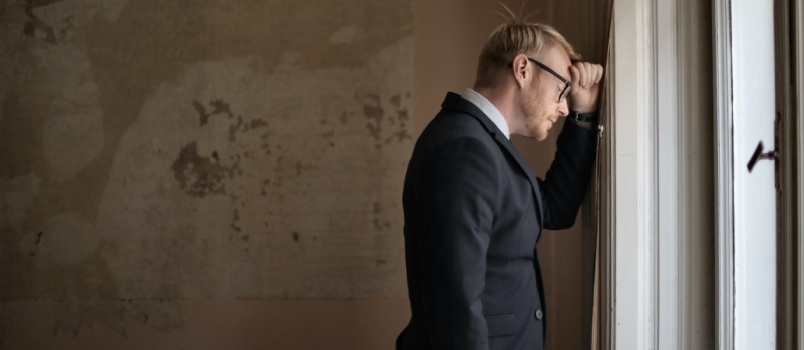 Depressed man laying on wall