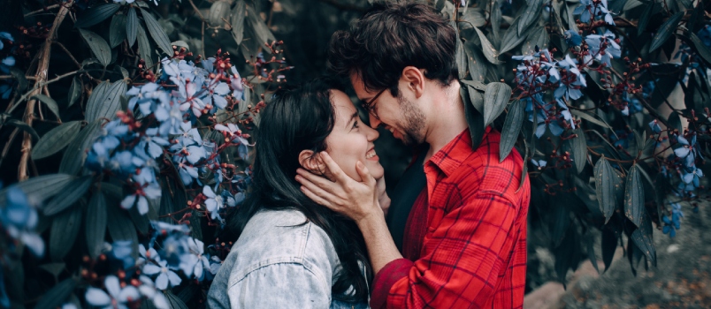 Man holding woman face