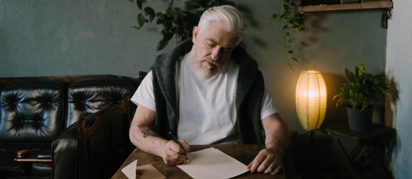 Elder man composing a letter