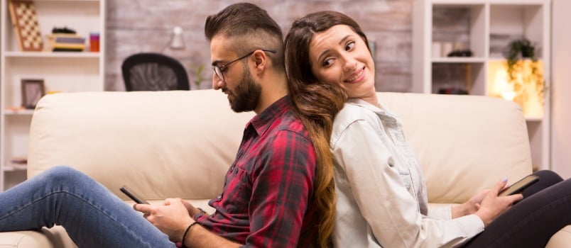 Girlfriend looking at her boyfriend sitting back to back 