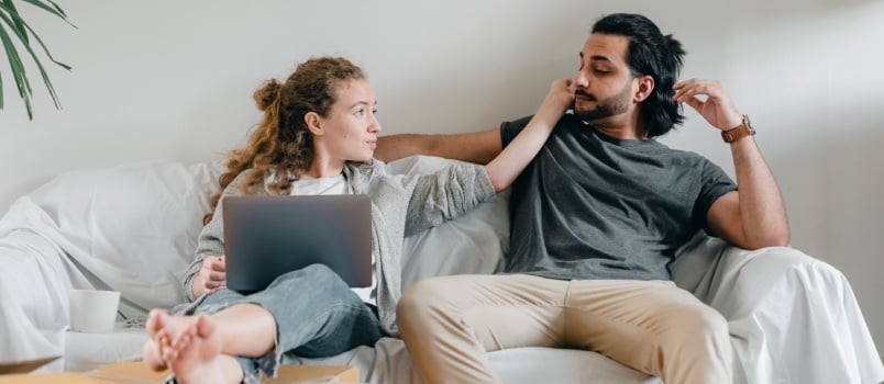Girlfriend with laptop touching man face