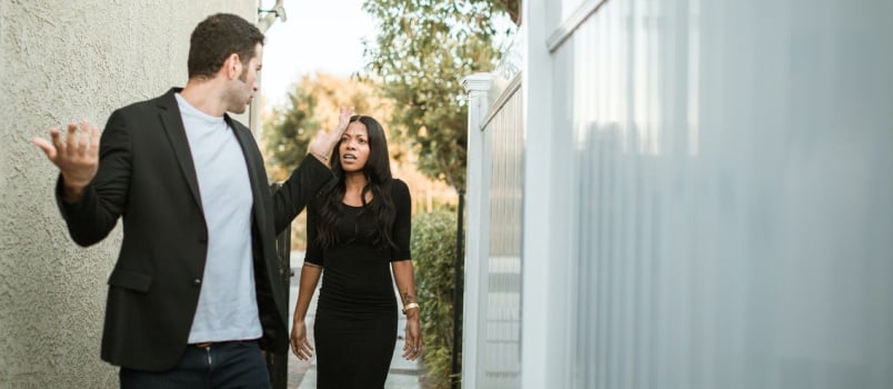 Man in black suit standing beside woman in black dress