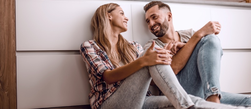Happy couple discussing something on kitchen floor