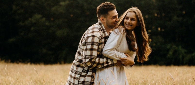 Man and woman standing on brown grass