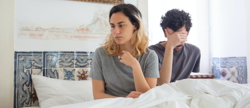 Woman in grey shirt sitting beside man