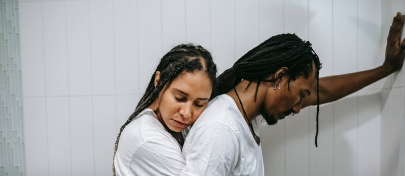 Woman hugging stressed husband