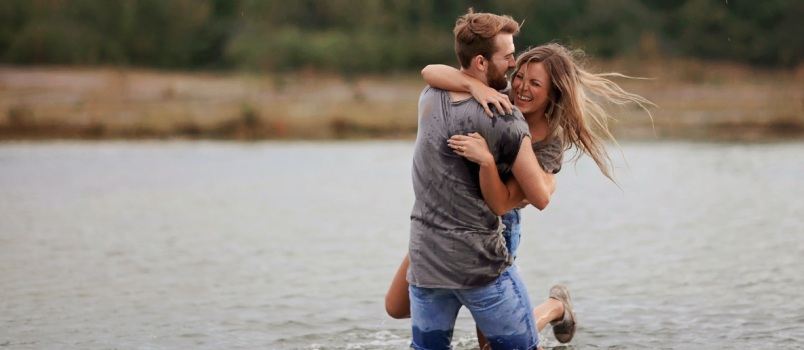 Man hugging woman while standing in water