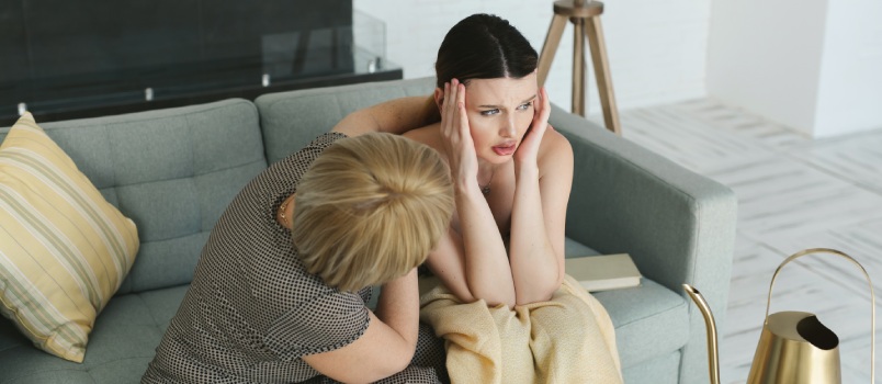 Young woman crying on sofa