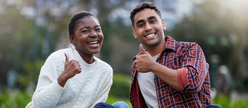 Young couple showing thumbs up