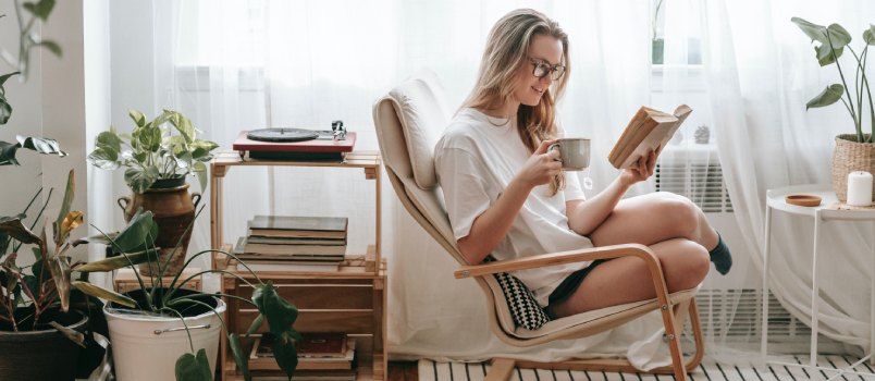 Woman drinking coffee while reading books