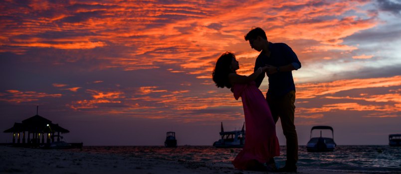 Man and woman on beach during sunset