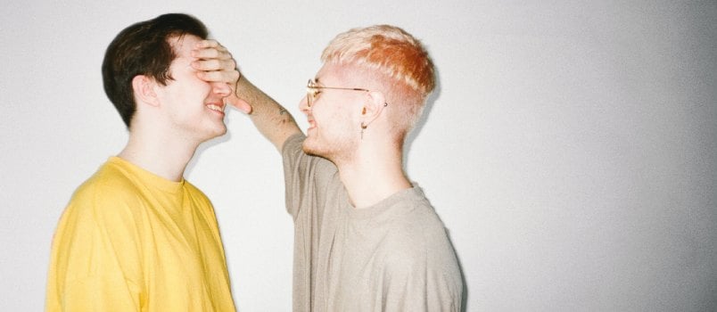 Man covering another man face with hand