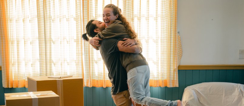 Un couple s'embrasse et déballe des cartons