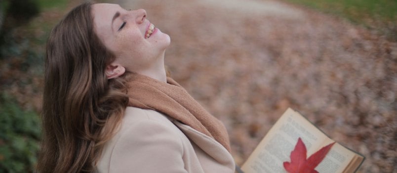 Cheerful woman reading book