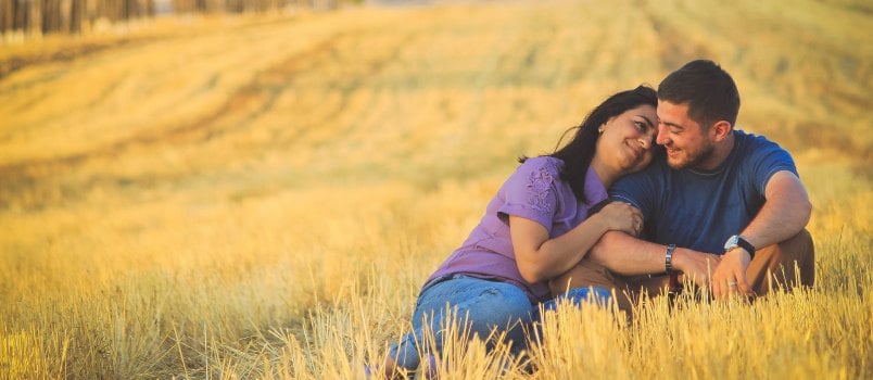 Man and woman sitting on grass field