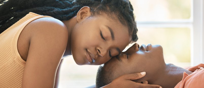 Woman touching man face while eyes close