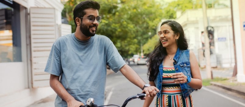 Couple walking on street with bicycle