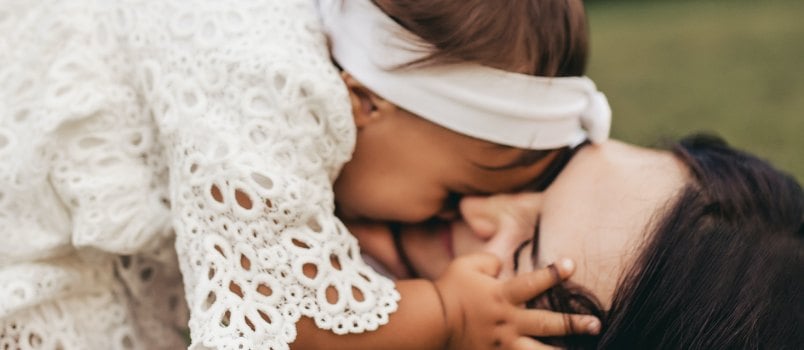 Woman kissing child