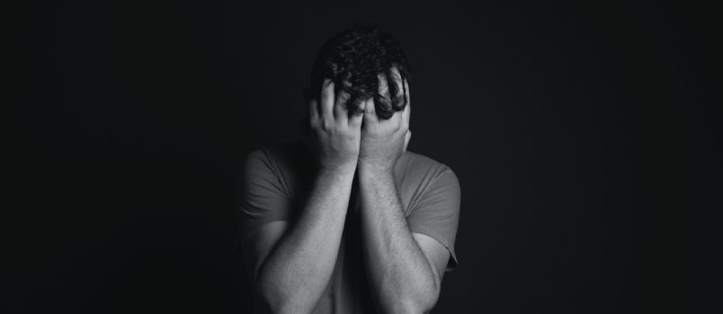 Man covering his face