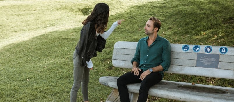 Woman in black jacket pointing at man