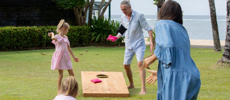 Family playing cornhole game