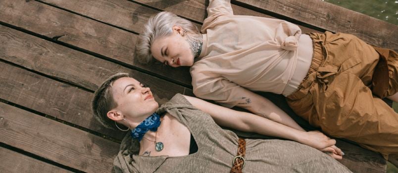 Two woman laying on wooden plank