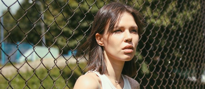 Woman leaning on chain fence