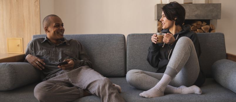 Couple talking while sitting on couch