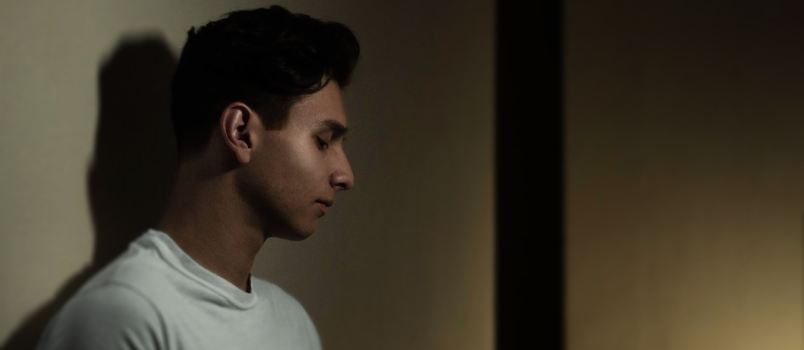 Sad man leaning on wall