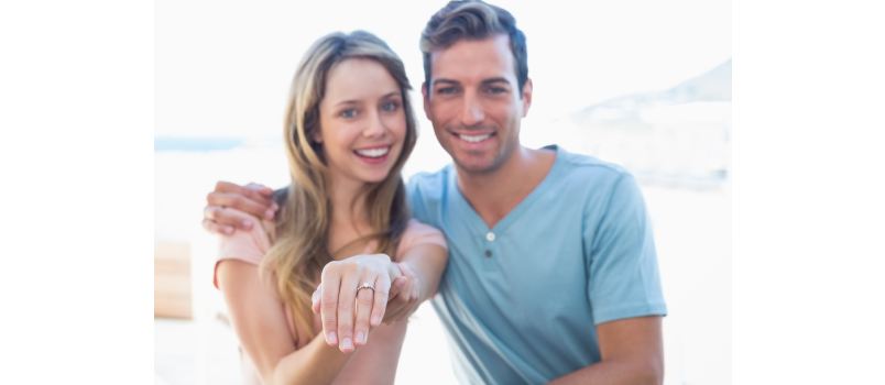 Happy young woman showing ring