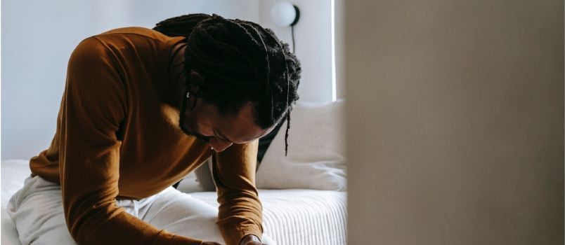 Depressed man sitting on bed