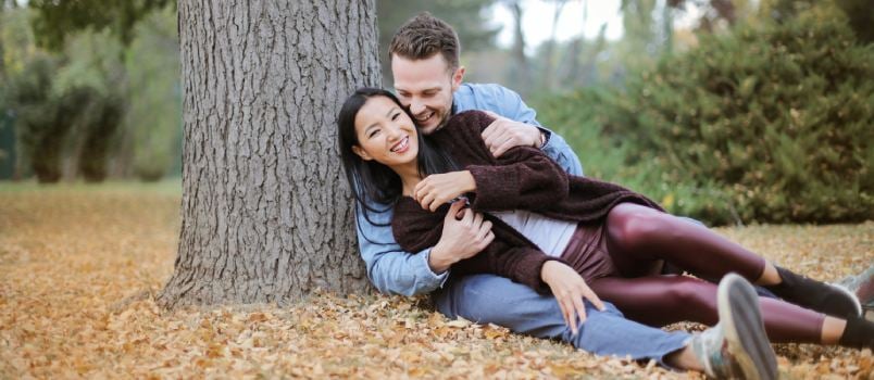 Couple reclining under tree