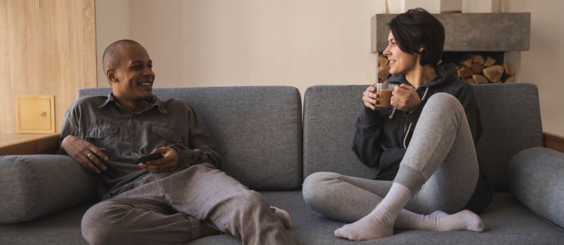 Couple talking while sitting on couch