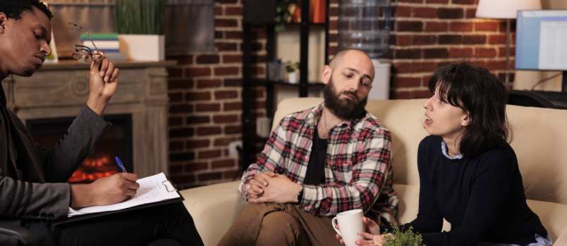Worried couple talking to counselor
