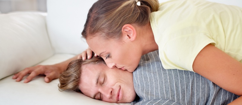 Woman kissing man while he is sleeping 