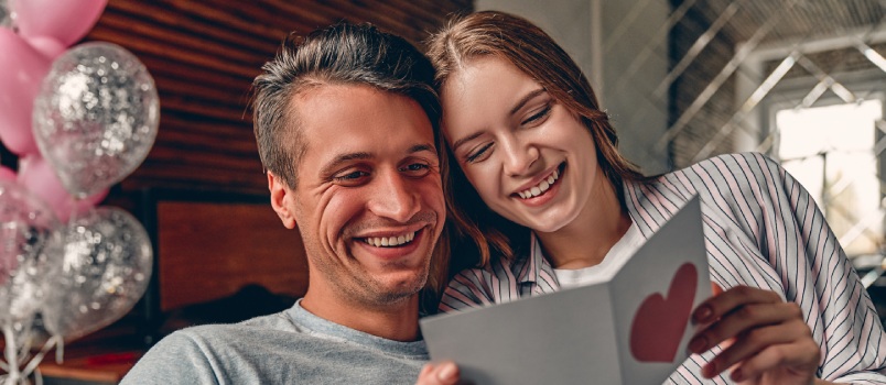 Young couple reading card together