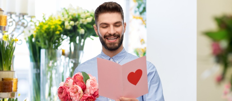 Man reading card and holding flowers