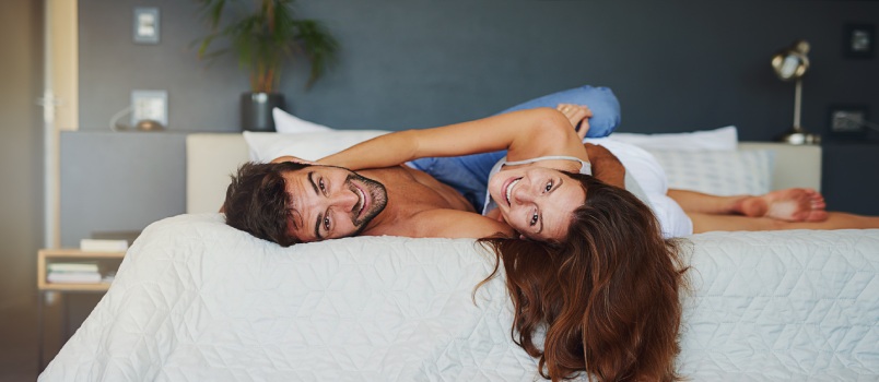 attractive couple laying on bed \