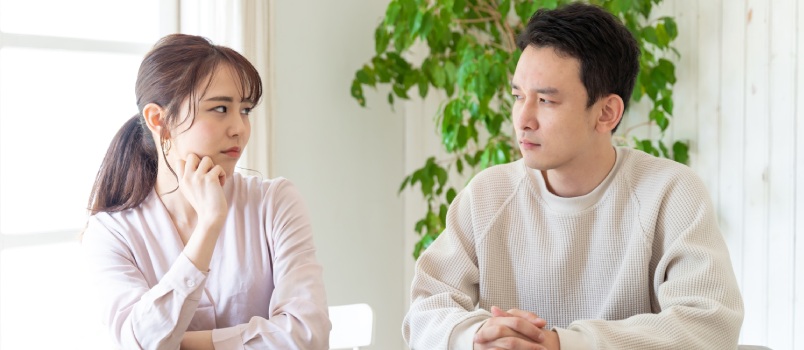 Young couple sitting on table looking at each other